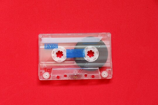 Vintage audio cassette tape on a red background. Old cassette tape with copy space. 