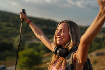 Naklejka premium Woman hiker celebrating success raising arms on mountain