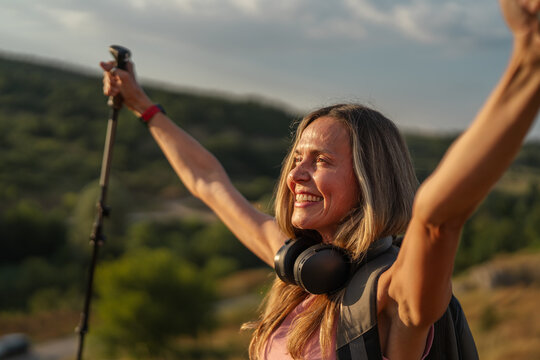 Woman hiker celebrating success raising arms on mountain