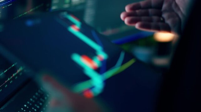 Financial analyst analyzing stock market candlestick charts tablet computer screen. Professional business investor reviews live trading data, cryptocurrency trends, and share prices