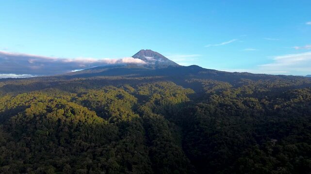 Wide Aerial View of Volcano and Tropical Rainforest in Ecuador, Green Forested Foothills, Blue Sky and Scenic Andean Amazon Wilderness Landscape