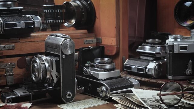 Old cameras in a composition on a wooden background, slowly moving in a horizontal plane.