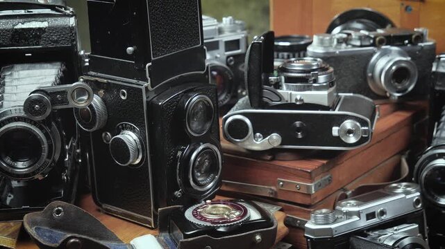 Old cameras in a composition on a wooden background, slowly moving in a horizontal plane.