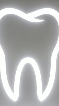 Vertical video: Zooming camera tilting up in clinic, highlighting upper cusp on neon tooth halo