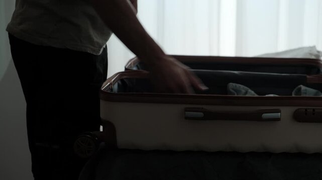 Constant relocation and temporary living. Close up of packing personal belongings into suitcase before another move, authentic lifestyle routine