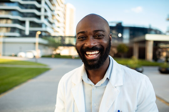 Portrait of smiling doctor outside modern hospital