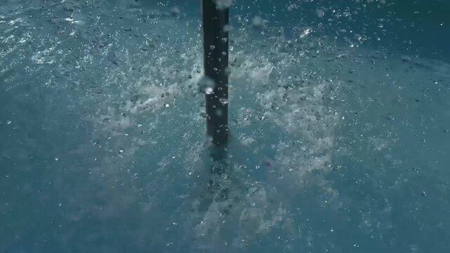 Mushroom fountain pouring water into swimming pool close up