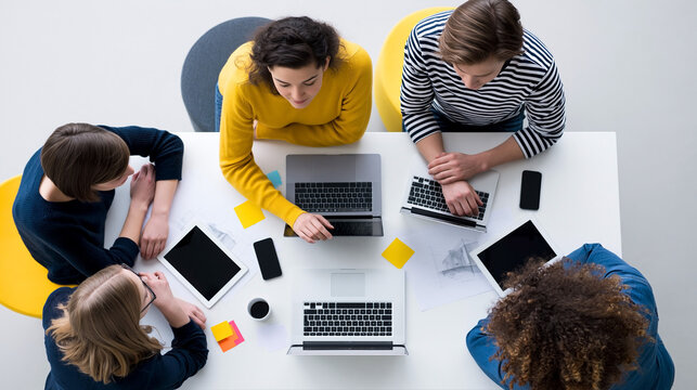 Business team collaborating around laptops in modern office meeting