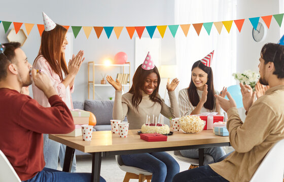 Friends happy birthday candle cake celebration, african american woman, friendly group portrait applauding on party together for event smiling people gathering making fun, enjoy time wishing happiness
