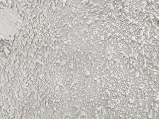 Background of uneven white acoustic wall texture with abstract grain patterns accentuates the modern industrial aesthetic. Close-up of handmade popcorn ceiling has dramatic shadows for decoration. © Windi Holly