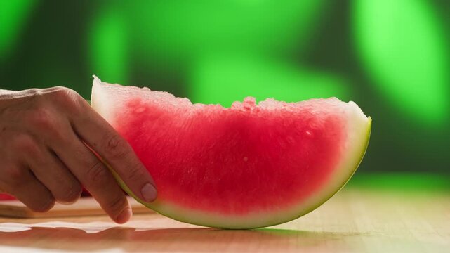 Man cutting watermelon - cut piece with knife. Young watermelons Citrullus lanatus. Topic - melons and gourds, farmer cultivation of watermelons