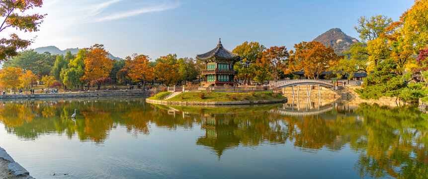 View of Hyangwonjeong Pavilion at Gyeongbokgung Palace with autumn colors during golden hour in Seoul, South Korea