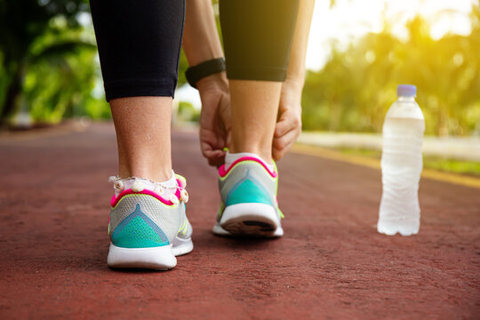 Woman tying up laces of shoes, getting ready to run for cardio and weight loss
