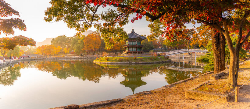 View of Hyangwonjeong Pavilion during sunset in autumn with colorful leaves near a calm pond in Seoul, South Korea