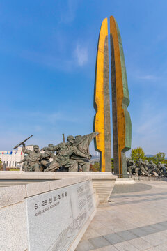 Large monument at the War Memorial of Korea with soldiers engaging in a battle scene on a clear day in Yongsan District, Seoul, South Korea