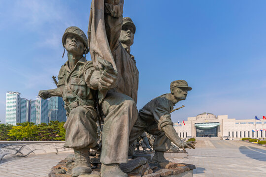 View of sculptures at War Memorial of Korea on a sunny day in Yongsan District, Seoul, South Korea, Asia with city buildings in the background