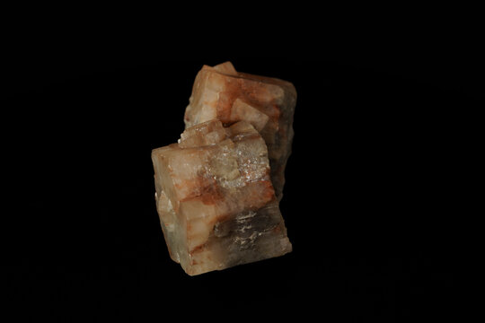 Two translucent, rough-textured mineral crystals sit isolated on black background.