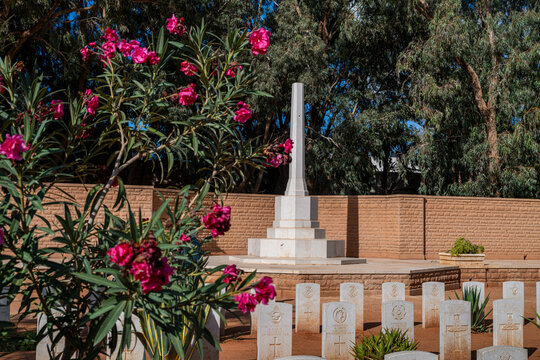 British World War 2 cemetery in Benghazi with memorial and flowers in the foreground and graves in sight
