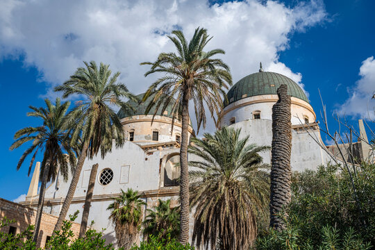 Old cathedral with domes and palm trees in Benghazi, showcasing architectural details and natural surroundings in Libya