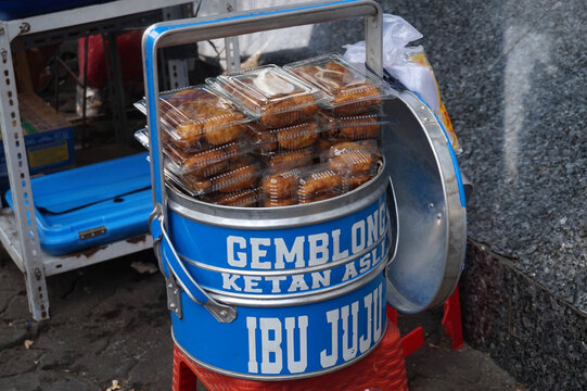 JAKARTA, INDONESIA &ndash; JULY 17, 2026: A blue metal container displaying packed traditional sweet gemblong cakes at an Ibu Juju street vendor.