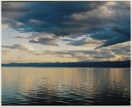 Lake at sunset under a dramatic sky, shot on film 