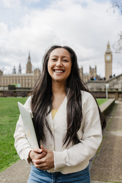 Student holding a laptop in front of Big Ben