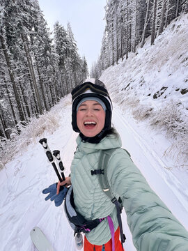 Happy woman enjoying a ski touring adventure in winter.