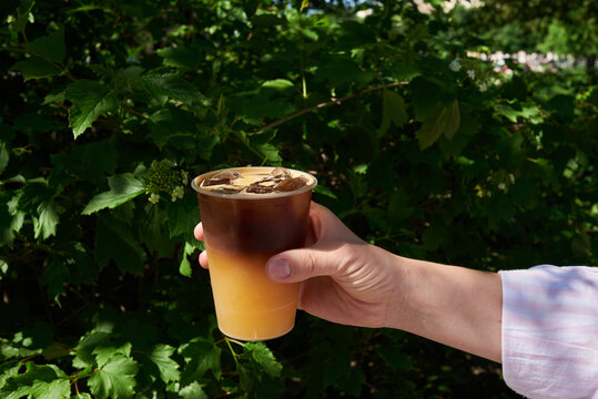 Anonymous woman holding coffee with ice