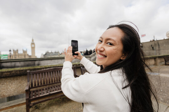 Smiling tourist recording Big Ben in London