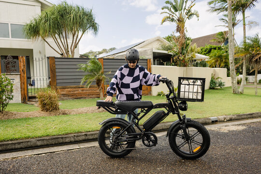 Man preparing e bike on residential street in coastal Australia