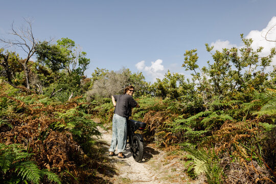 Man walking e bike along narrow coastal nature australian path