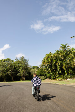 Rider looking back while cycling e bike through coastal suburb
