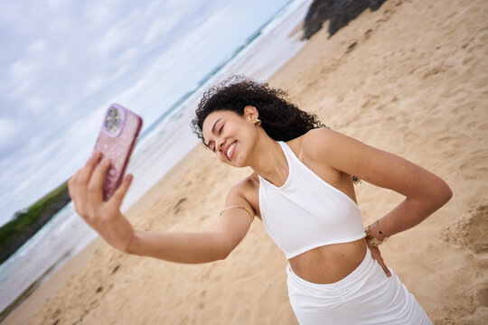 Woman smiling taking a selfie on beach vacation
