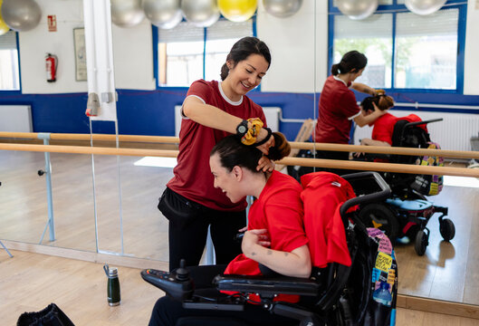 Woman assisting friend styling hair for inclusive activity