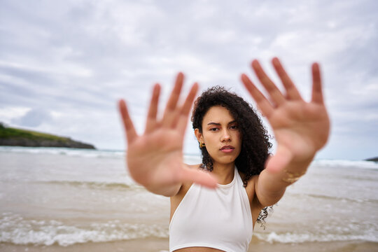 Woman making stop gesture expressing personal boundaries on beach