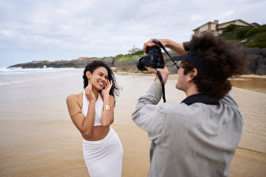 Photographer shooting portrait of model on beach