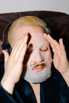 Man Adjusting Sheet Face Mask During Self Care Routine
