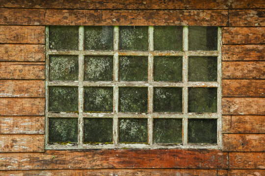 Old weathered window on rustic wooden wall