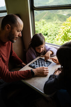 Family Enjoying Chess Game on Train Journey
