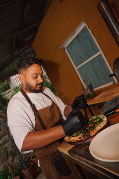 Chef Prepares Pizza With Fresh Ingredients Outdoors in Garden