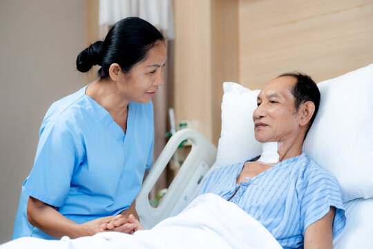 Elderly patient recovering in a hospital bed while a dedicated nurse documents health progress reflecting professional caregiving trust and continuous treatment.
