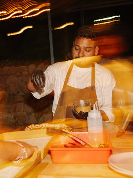Chef Prepares Neapolitan Pizza at Outdoor Event During Evening Time