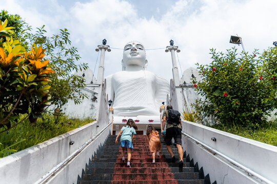 Family Climbing Steps to Majestic Buddha Statue, Kandy, Sri Lanka
