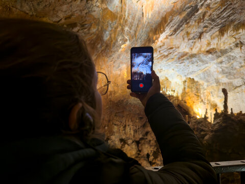 Tourist Recording Cave Formations on Smartphone