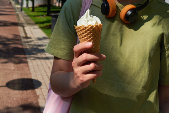 Anonymous teenager holding an ice cream in a cone