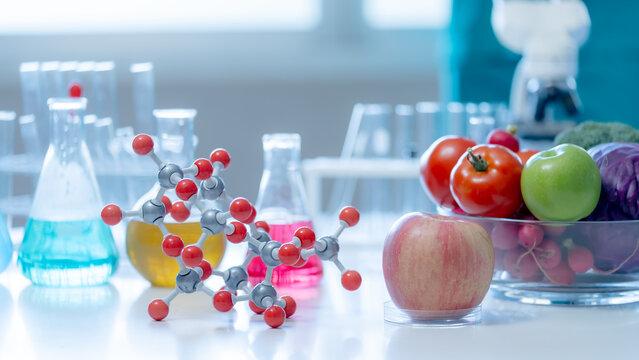 Fresh apple tomatoes and molecular structures displayed in a modern laboratory illustrating nutrition science food quality research and healthy living solutions.
