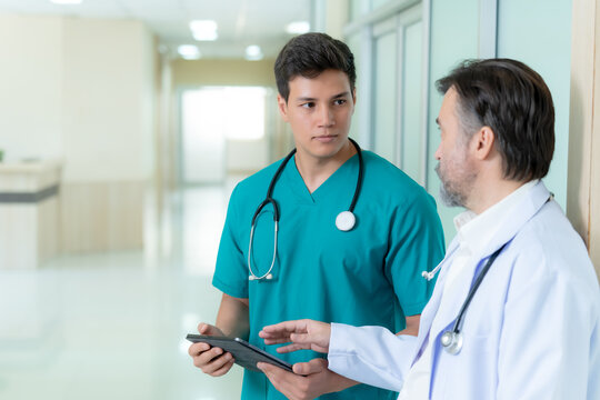 Doctor and nurse reviewing patient data on a digital tablet inside a bright medical facility representing healthcare innovation collaboration and efficient clinical workflow.
