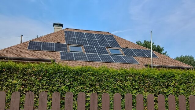 Solar panels on a house roof, representing energy savings, reducing high electricity bills and renewable power investments. Solar panels on a roof.