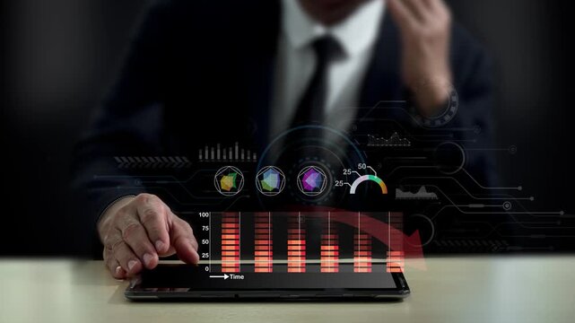 Businessman using a tablet to analyze virtual financial graphs with a decreasing red arrow, representing corporate risk management, business cost reduction, and budget optimization planning.