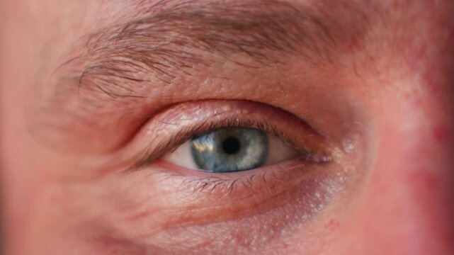 Extreme Close Up Male blue Eye Blinking And Looking Around In Dark, middle aged portrait